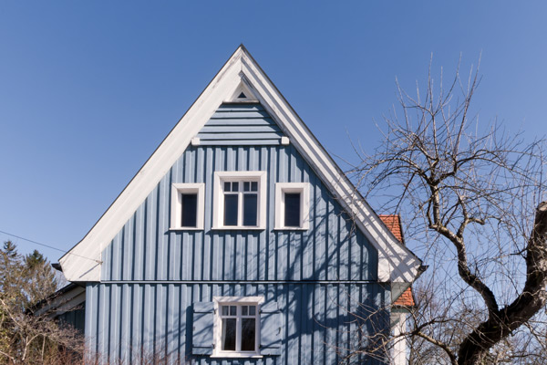 blaues Schwedenhaus mit weißen Holzfenstern