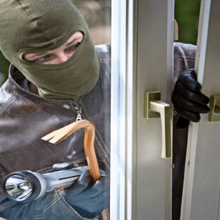 Einbrecher versucht durch ein Fenster einzubrechen